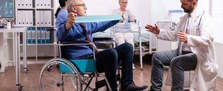 disabled-senior-man-doing-his-exercises-hospital-with-doctor-min